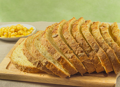 由桌上的玉米制成的面包放在砧板上的玉米面包片图片