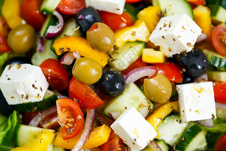 新鲜的特写蔬菜希腊沙拉配羊乳酪黑橄榄和绿橄榄樱桃番茄黄胡椒红洋葱黄图片