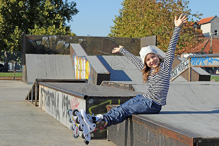 在操场上玩溜冰鞋的快乐小女孩图片