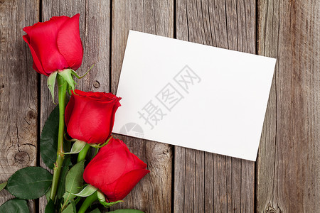 红玫瑰和贺卡在木制背景上顶视图背景图片