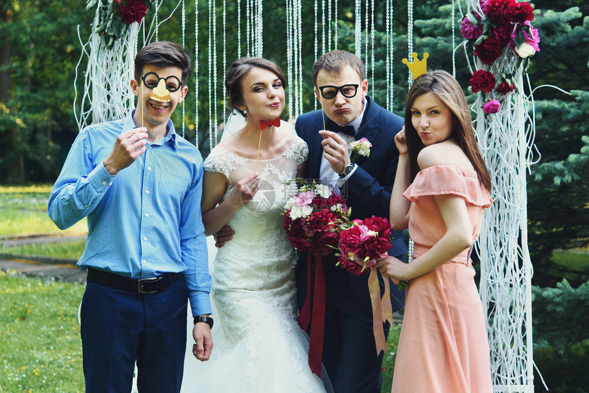 优雅时尚的快乐宾客新娘和新郎在拱门背景上挂图片