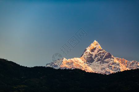 喜马拉雅山脉鼓舞人心的美丽日落景观喜马拉雅山峰Machhapuchhare6993mASL在蓝色晴朗的图片