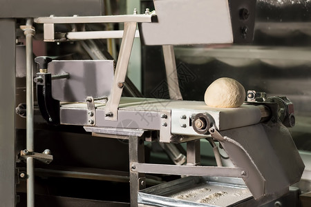 面包店生产甜品厂面包生产车间传送带上的包子用于生产图片