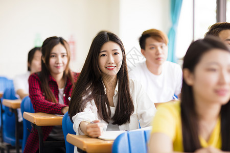 与同学坐在一起微笑的女大学生图片