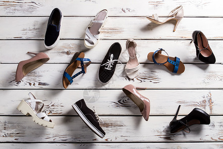 不同的鞋子放在地板上女士鞋类木制背景上鞋店地板上一团糟鞋子从架图片