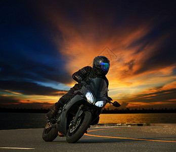 年轻人骑着大型自行车摩托车在沥青高速公路上倾斜曲线图片