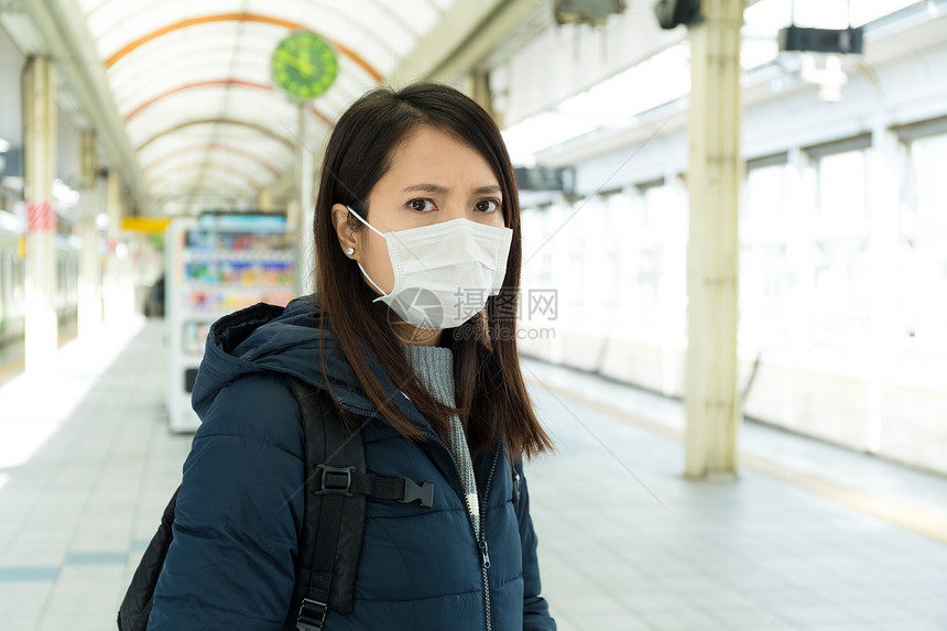 在火车站戴口罩的亚洲年轻女子图片