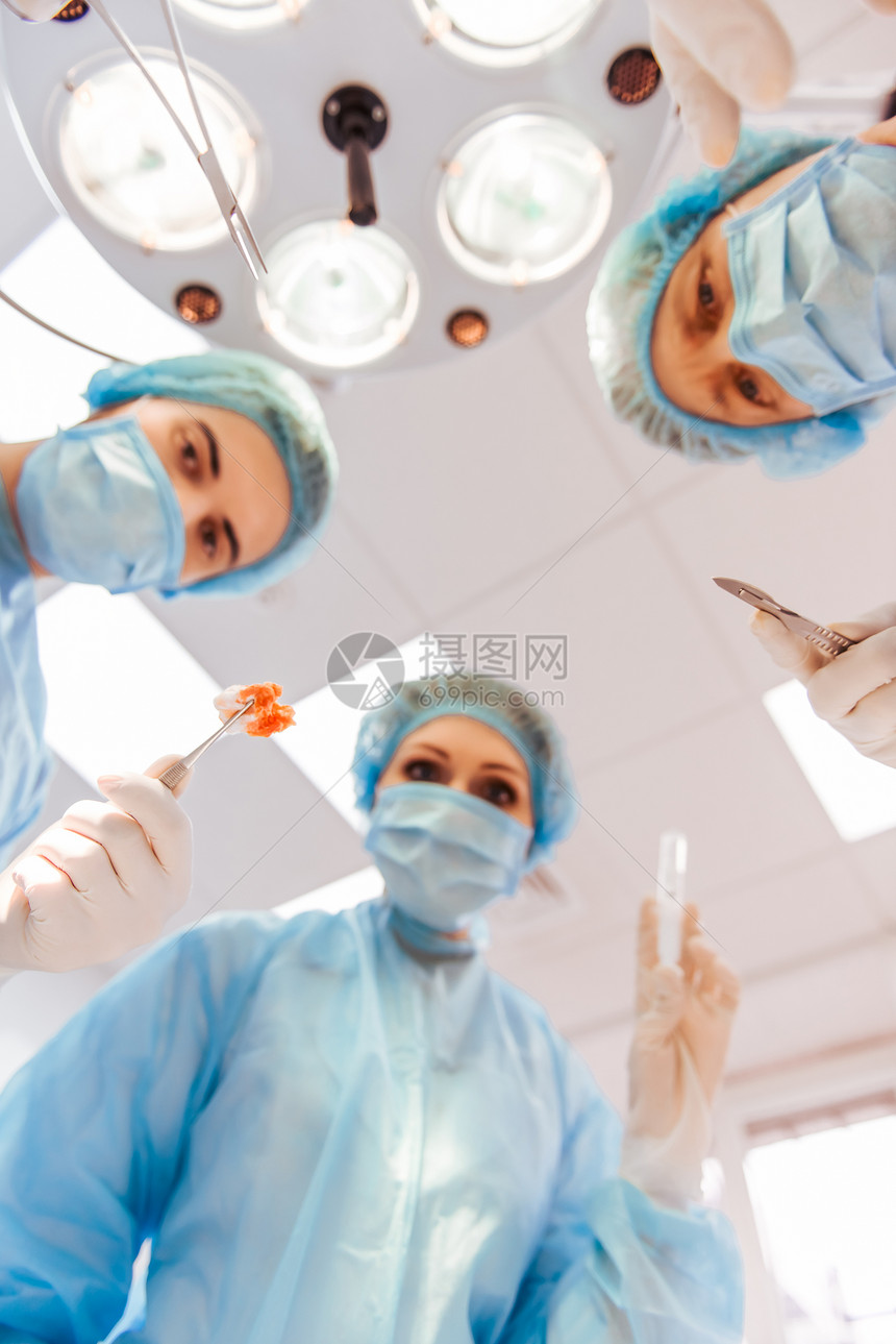 队外科医生使用医疗仪器在现代手术室底视下线图片