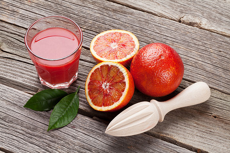 木桌上的红橙子和果汁杯图片