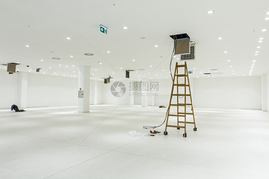 工人用木制梯子完成现代办公天花板的空调系统通风图片