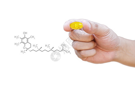 手握维生素E丸与剪报图片
