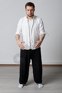练习穿白衬衫和黑裤子的年轻男背景图片