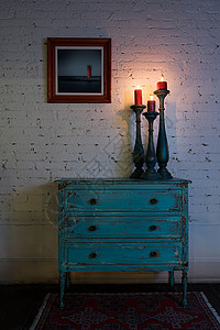 绿色古董柜蜡烛台和灯烛具以及挂在工作室白砖墙壁上的挂图片