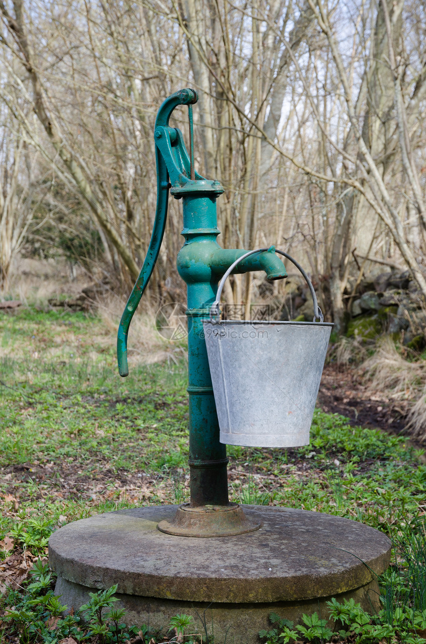 带桶的老式绿色手动水泵图片