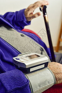 用电子血压计测量一个白人老的血压图片
