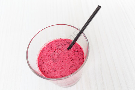 健康的有机食品白木背景玻璃杯中的草莓果汁冰沙图片