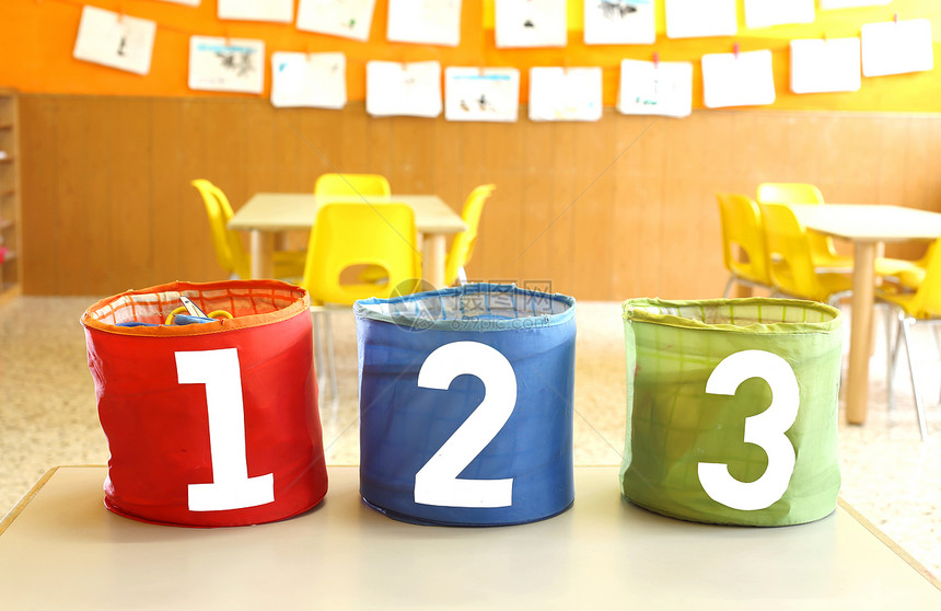 红绿色和蓝色罐子在童年学校教室桌上写一图片