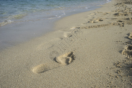 细沙滩表面有人的脚印背景图片