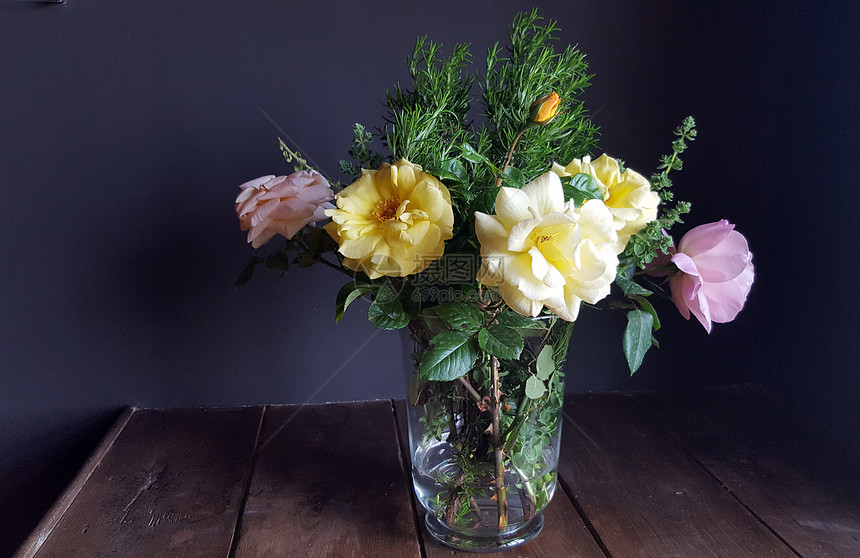 木桌上花瓶里的美丽玫瑰花图片
