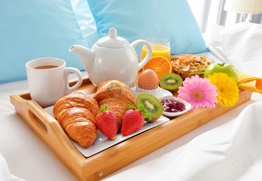 酒店房间床上的早餐托盘图片