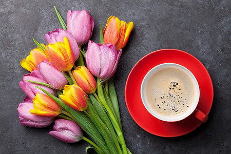 深色石桌上新鲜五颜六色的郁金香花和咖啡杯顶视图背景图片