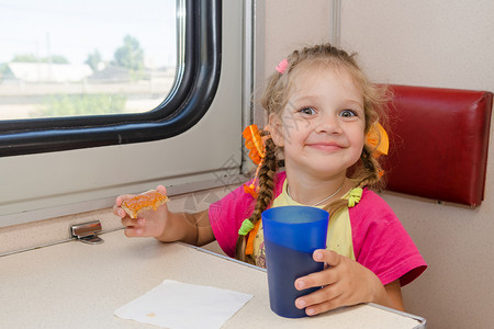 坐在二等车厢外边餐桌上的小女孩在火车上图片