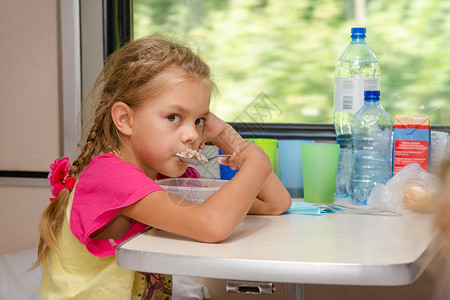一个六岁的火车上的女孩坐在车厢二等车厢下层的图片