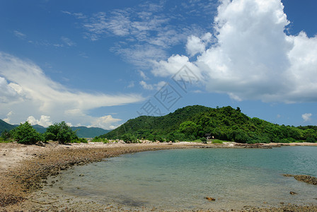 云山和蓝天的岩石海滩图片
