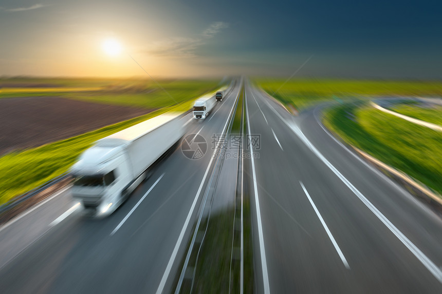 三辆新卡车连续快速驶向太阳高速公路上的速度模糊运动驱器塞尔维亚贝尔格莱德附近高速公路上的货运场图片
