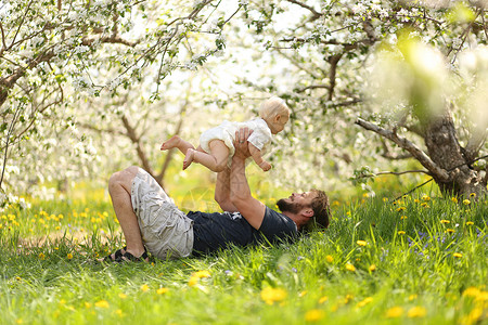 一个快乐的年轻父亲在春天的一天图片