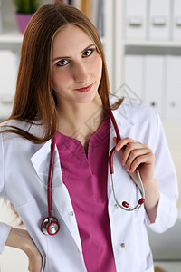 美丽微笑的女医生站在办公室拿着听诊器肖像图片