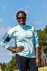 身着智能手表和智能手机的非洲年轻妇女近距离露天肖像图片