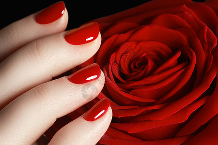 美丽指甲的特写照片美甲广告的好主意玫瑰在手黑色背景下手持玫瑰图片