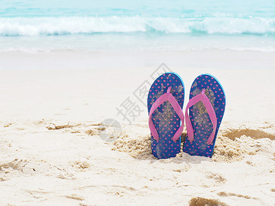 夏日沙滩上的蓝色拖鞋图片