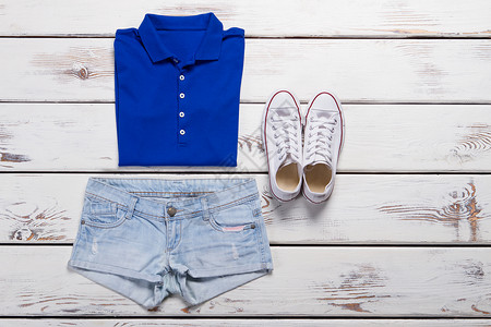 蓝色马球衬衫和轻牛仔裤白色时装运动鞋图片