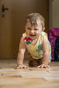 一岁小孩在地板上爬着看相机笑图片