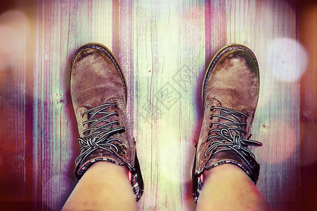 木质表面上带皮靴的脚图片