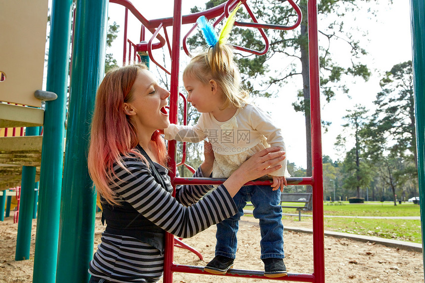 女孩和母亲在公园中玩操场梯子图片