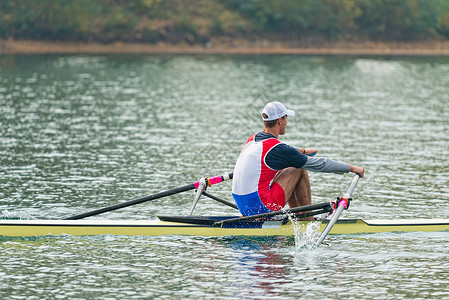 单人双桨运动在湖上划船图片