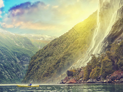 挪威码头的海上皮艇背着瀑布的图片