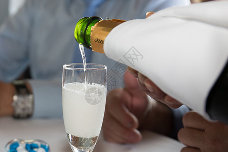 在庆祝活动中将香槟倒入玻璃杯中图片