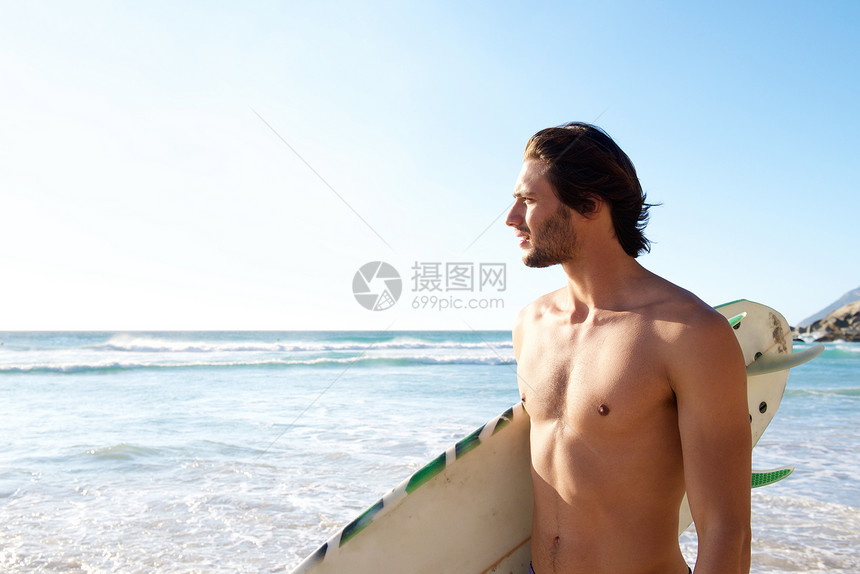 英俊男子在海滩冲浪图片