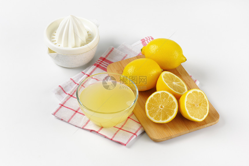 鲜柠檬汁柠檬挤压器和成熟的柠檬图片