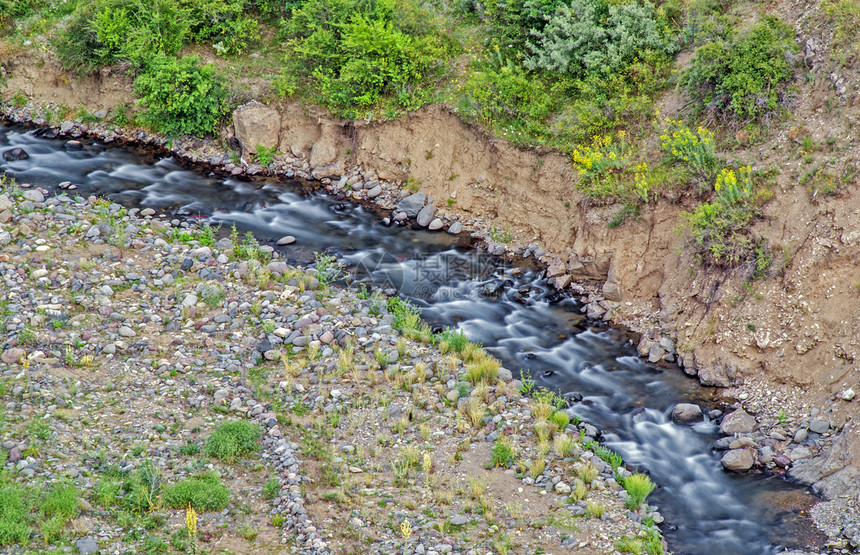 小溪流在岩石上喷涌长的物产生倾覆图片