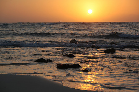 海上日出与海浪和岩石图片