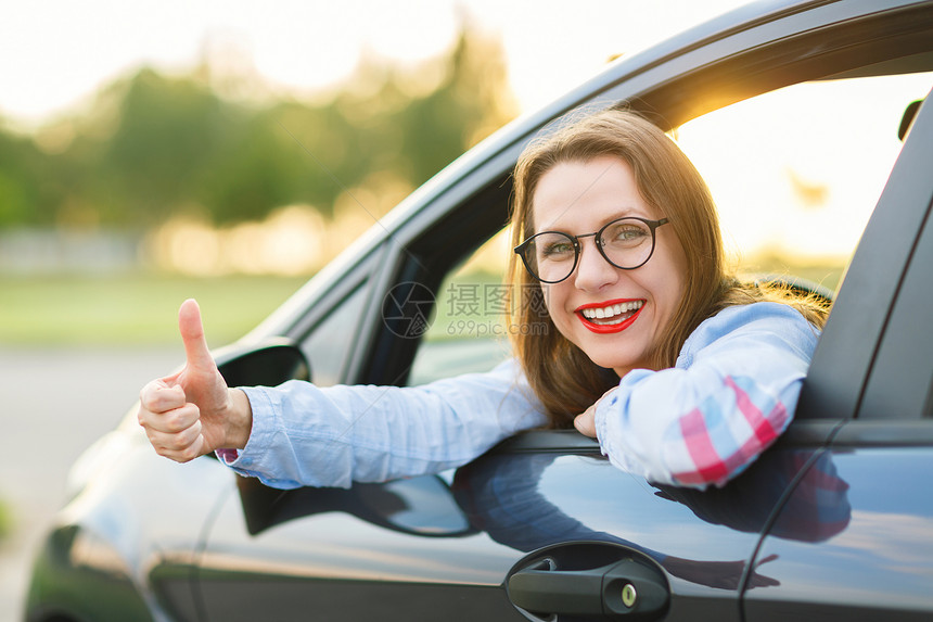 年轻快乐的女人坐在车里图片