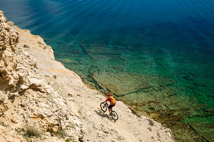 山地车手在海边和山地景观中骑自行车男子在耐力赛小径上骑山地车在优美的环境中运动健图片
