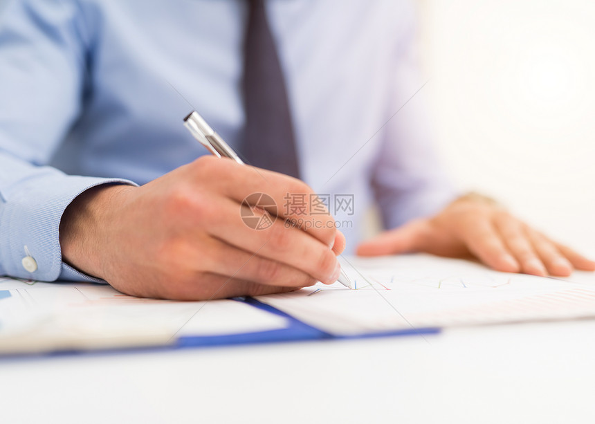 商人在文档中写作专注于笔尖图片