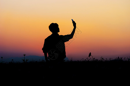 在夕阳的天空背景下摆姿势的人剪影图片