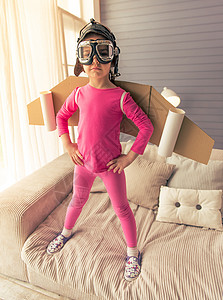 可爱的小女孩穿得像个带着玩具翅膀的飞行员图片
